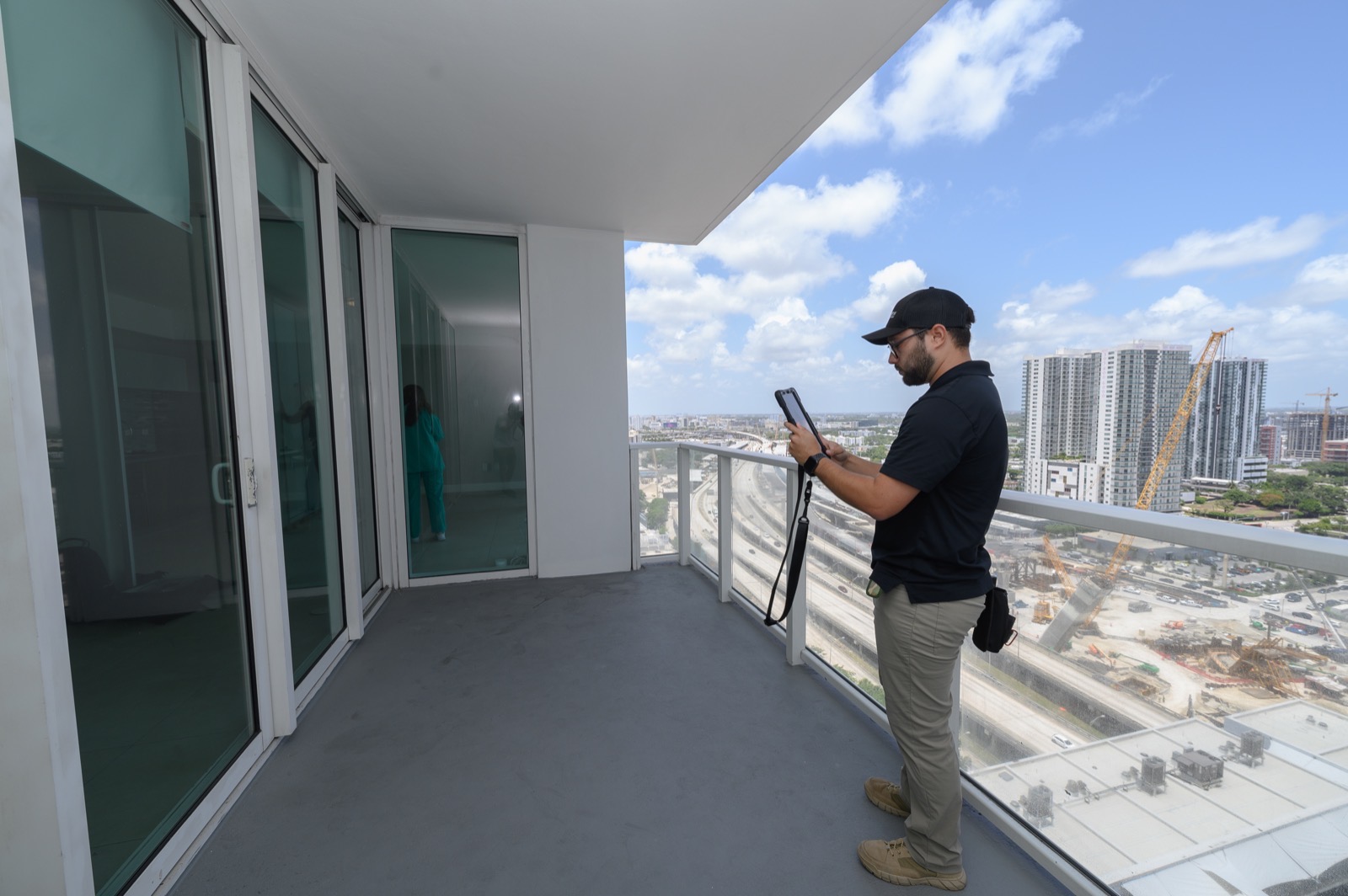 TruView Inspections inspector documenting a high-rise Miami condo balcony with the city skyline in view during a condo inspection