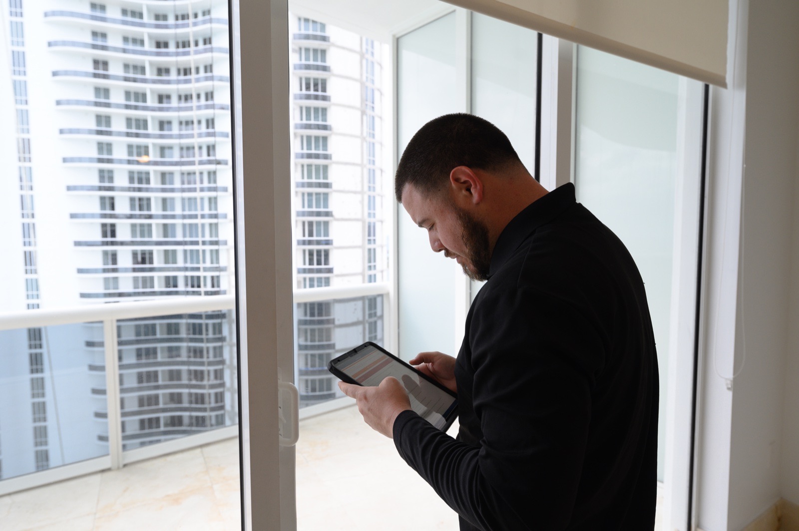 TruView Inspections home inspector reviewing findings on a tablet during a Miami high-rise condo inspection